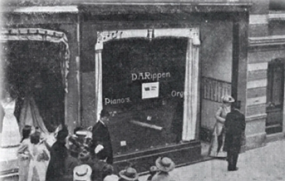 Black-and-white archive photograph of a shop window with Rippen lettering and people in the street